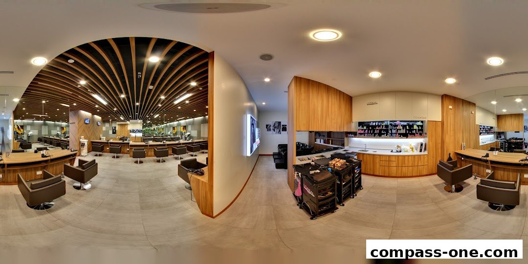 Interior view of a modern hair salon with styling stations and a color bar.