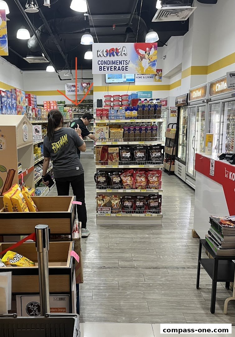 Interior view of a Korean mart with shelves stocked with snacks, beverages, and condiments.