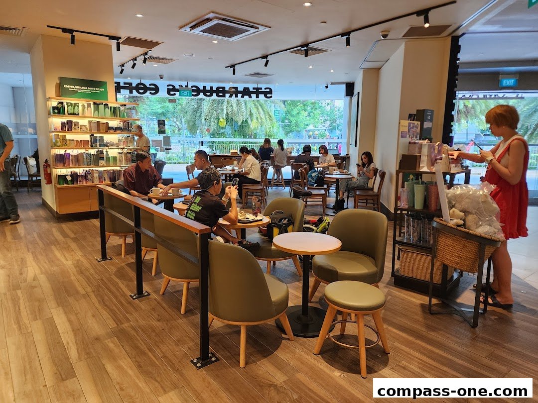 Interior of a Starbucks cafe with customers seated and merchandise displayed.