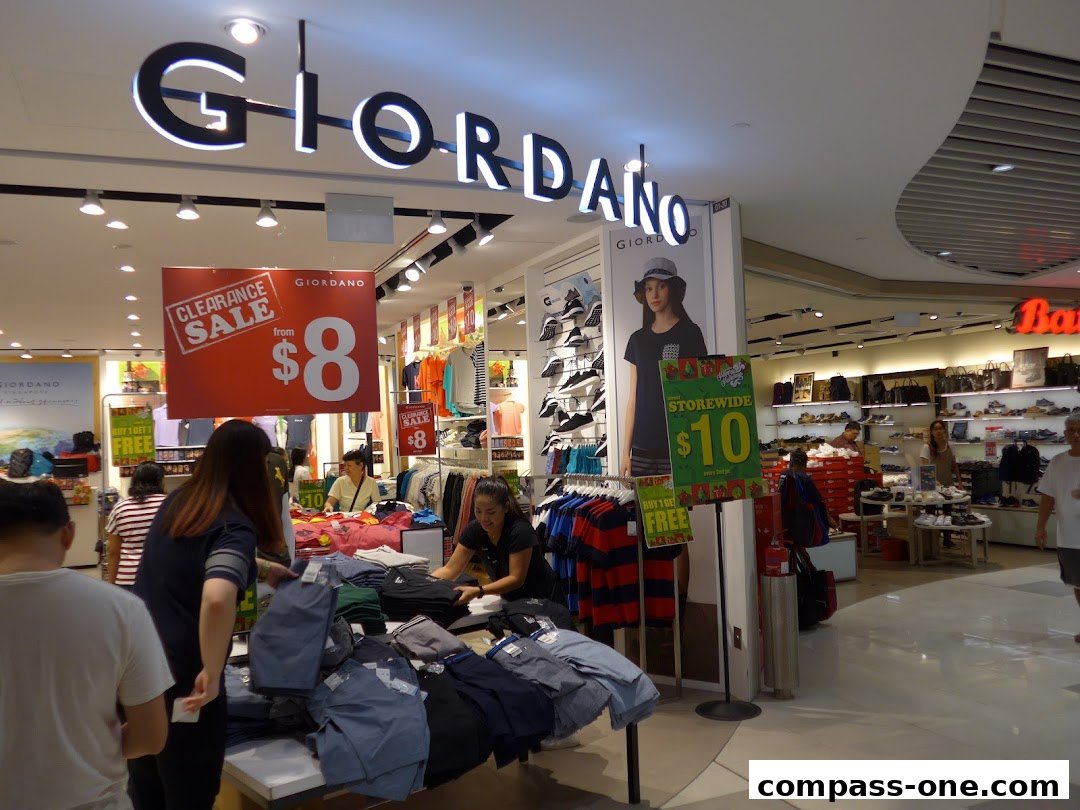 Interior view of a Giordano store with clothing displays and sale signs.