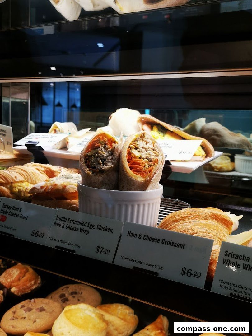 A display case filled with various pastries, wraps, and sandwiches at Starbucks.