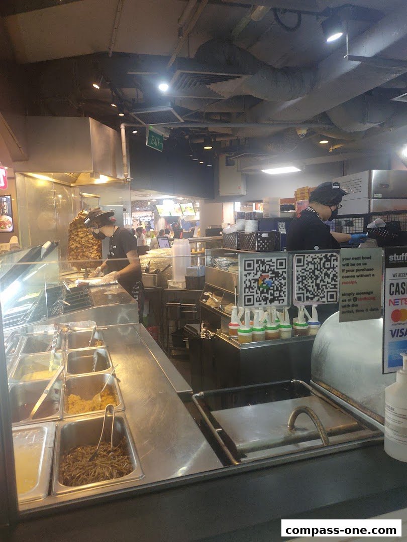 A food stall with staff preparing food and various ingredients displayed.
