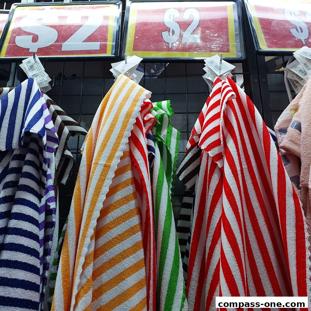 Colorful striped towels are displayed with '$2' price tags above them.