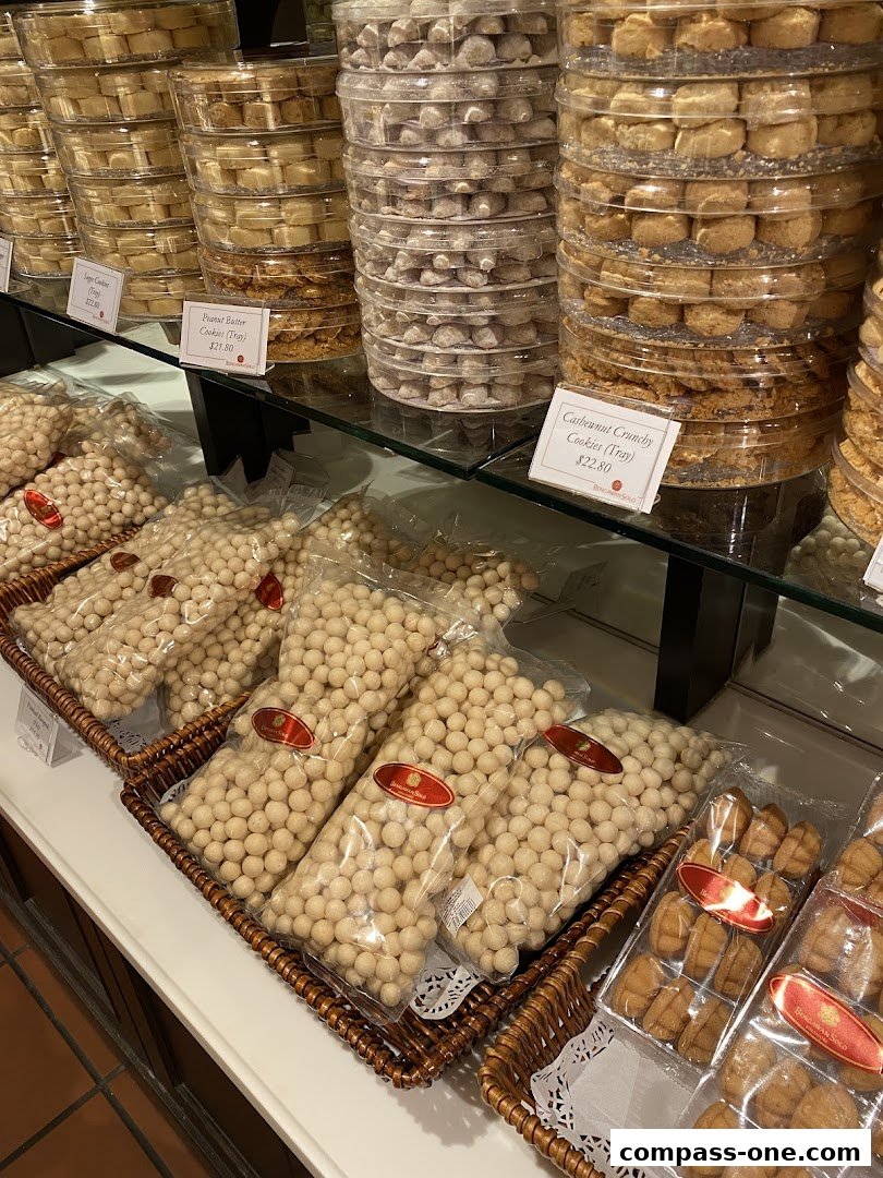A display of various cookies and snacks in clear plastic packaging and containers.
