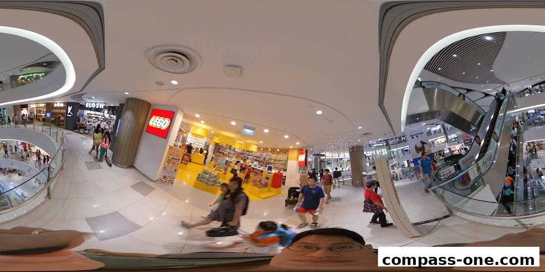 Interior view of a LEGO Certified Store with shoppers and escalators in a mall.