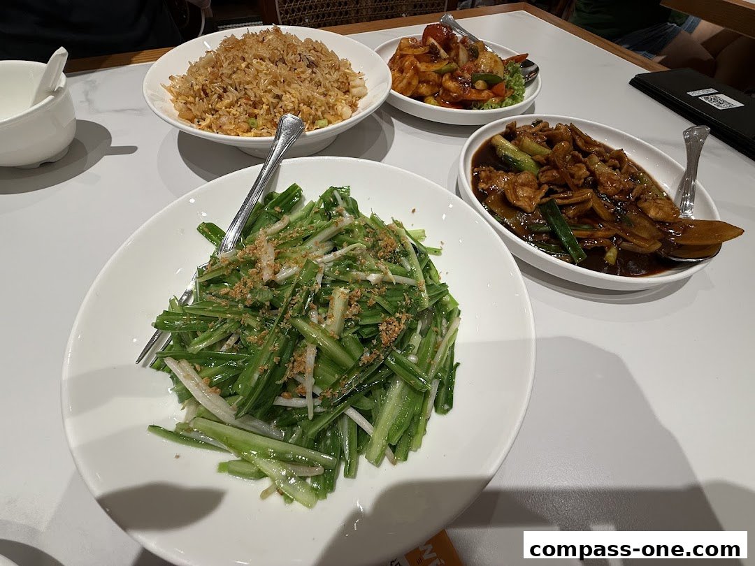 A table laden with various delicious Chinese dishes, including fried rice and stir-fried vegetables.