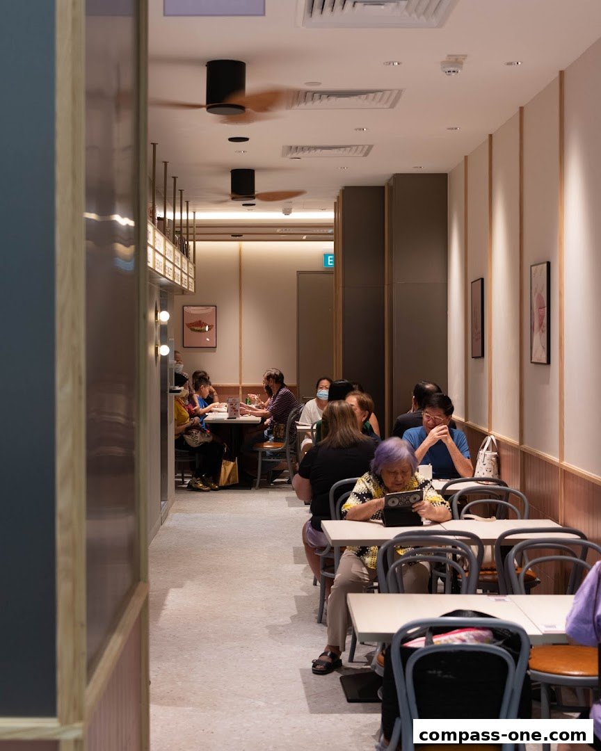 Diners seated at tables inside a brightly lit restaurant with ceiling fans.