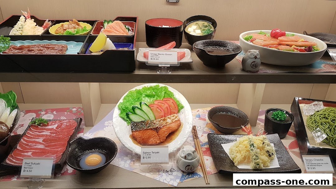 A display of realistic Japanese food items, including bento boxes, sushi, and noodles.