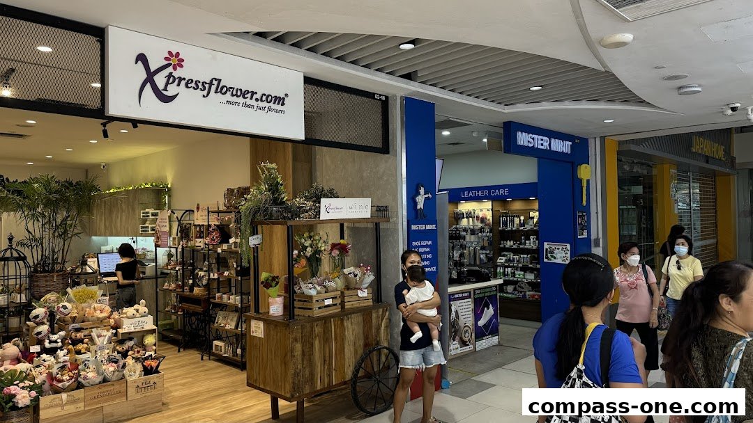 A flower shop and a Mister Minit store are visible in a mall corridor.