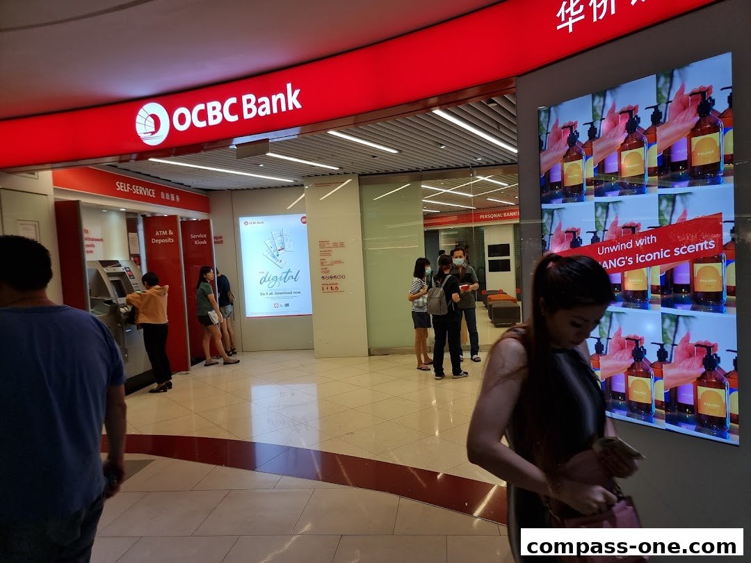 The entrance to OCBC Bank with self-service ATMs and a digital advertisement.