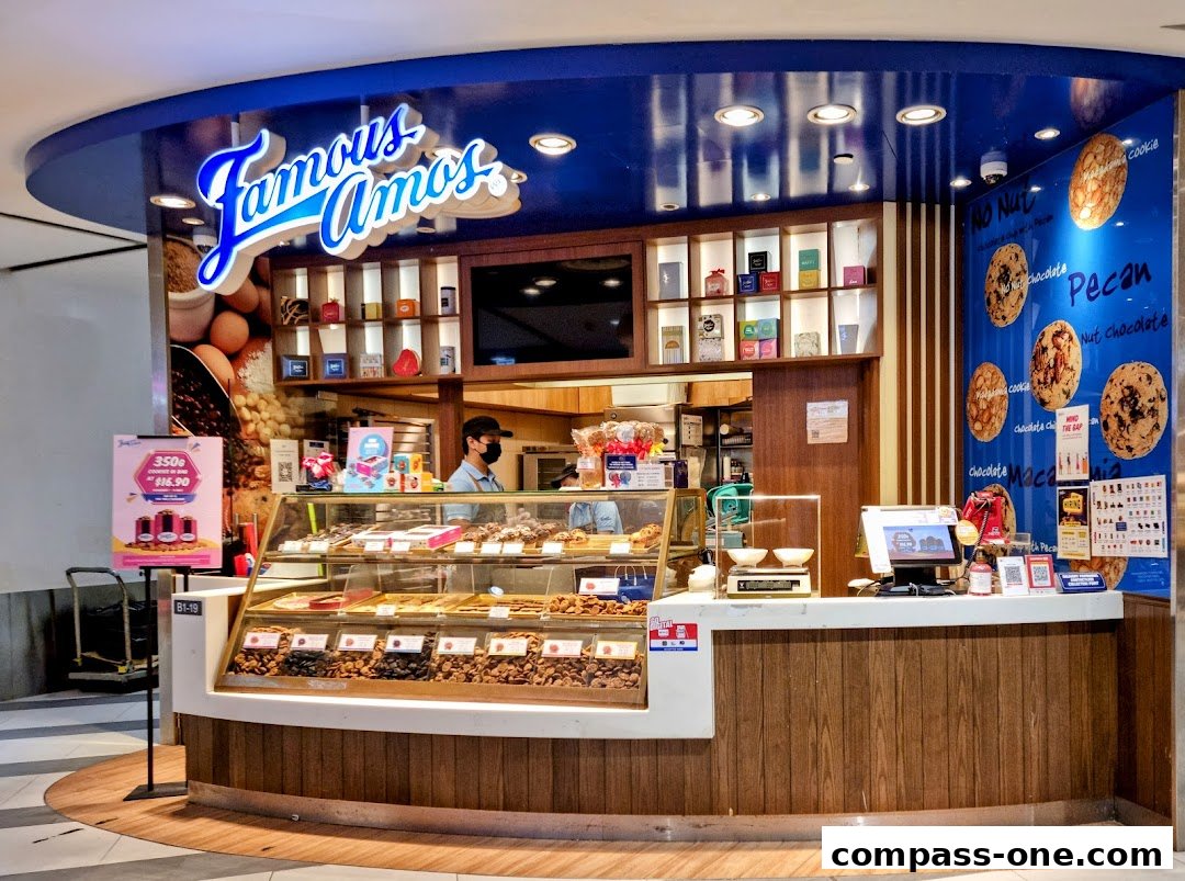 Famous Amos cookie shop with a display of various cookies and a counter with staff.