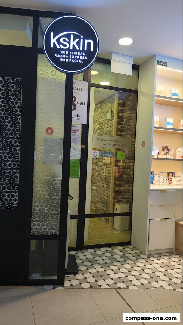 The entrance of Kskin Korean Express Facial shop with its illuminated sign and display shelves.