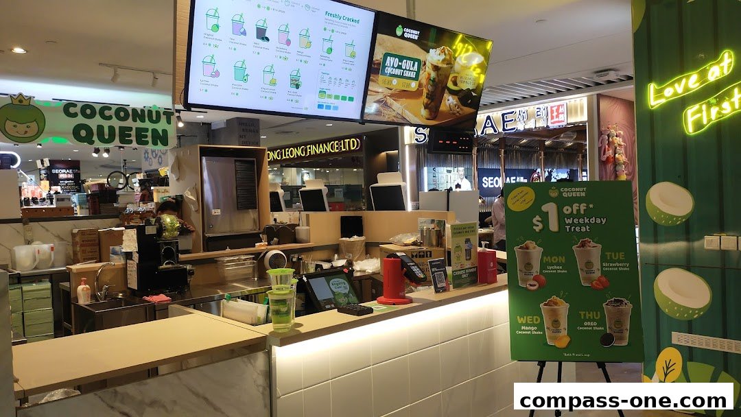 The Coconut Queen shop counter with a menu board, promotional posters, and drinks.