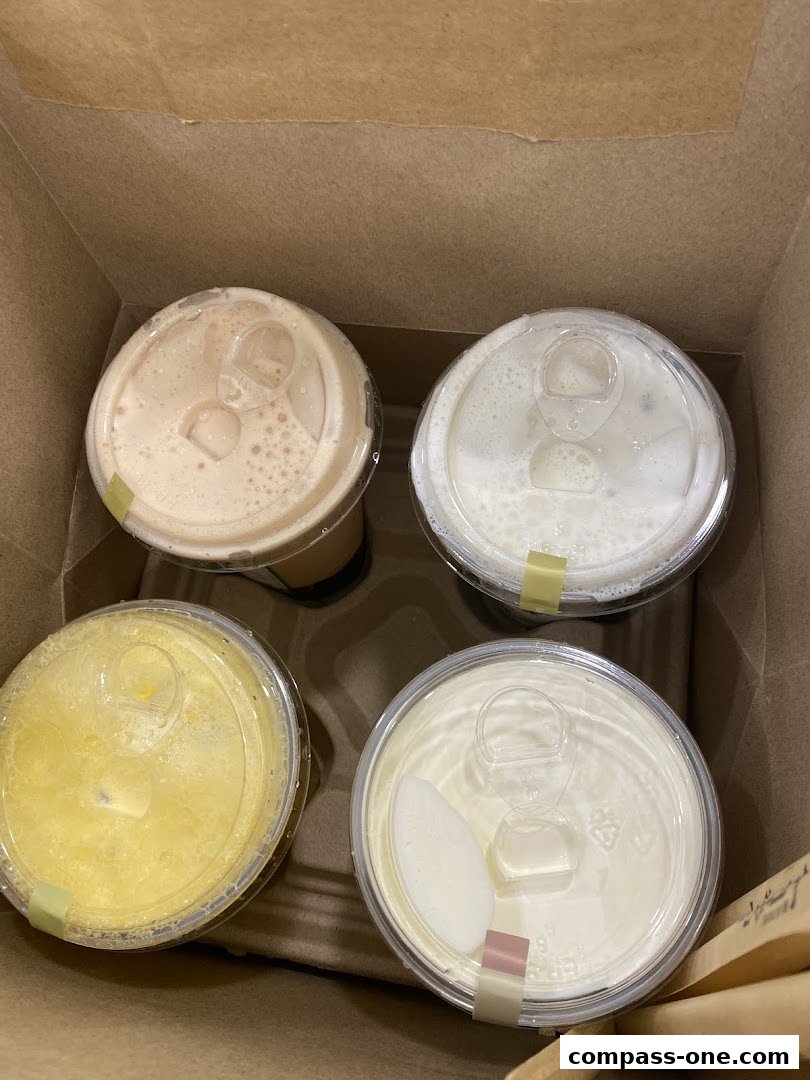 Four takeaway drinks in a brown paper bag, likely from a bubble tea shop.