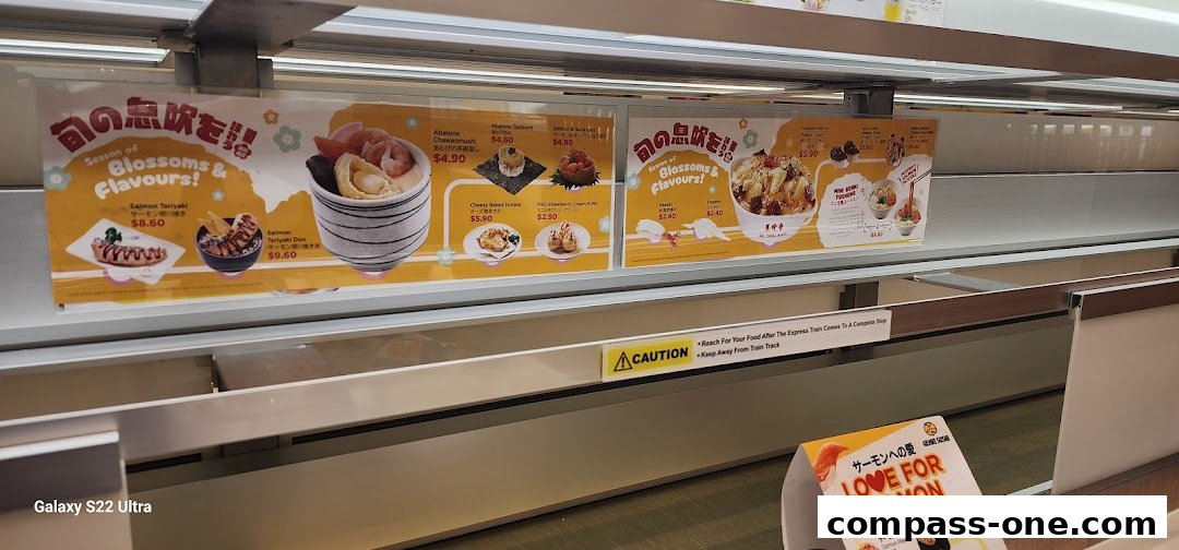 A conveyor belt sushi restaurant display featuring various sushi dishes and promotions.