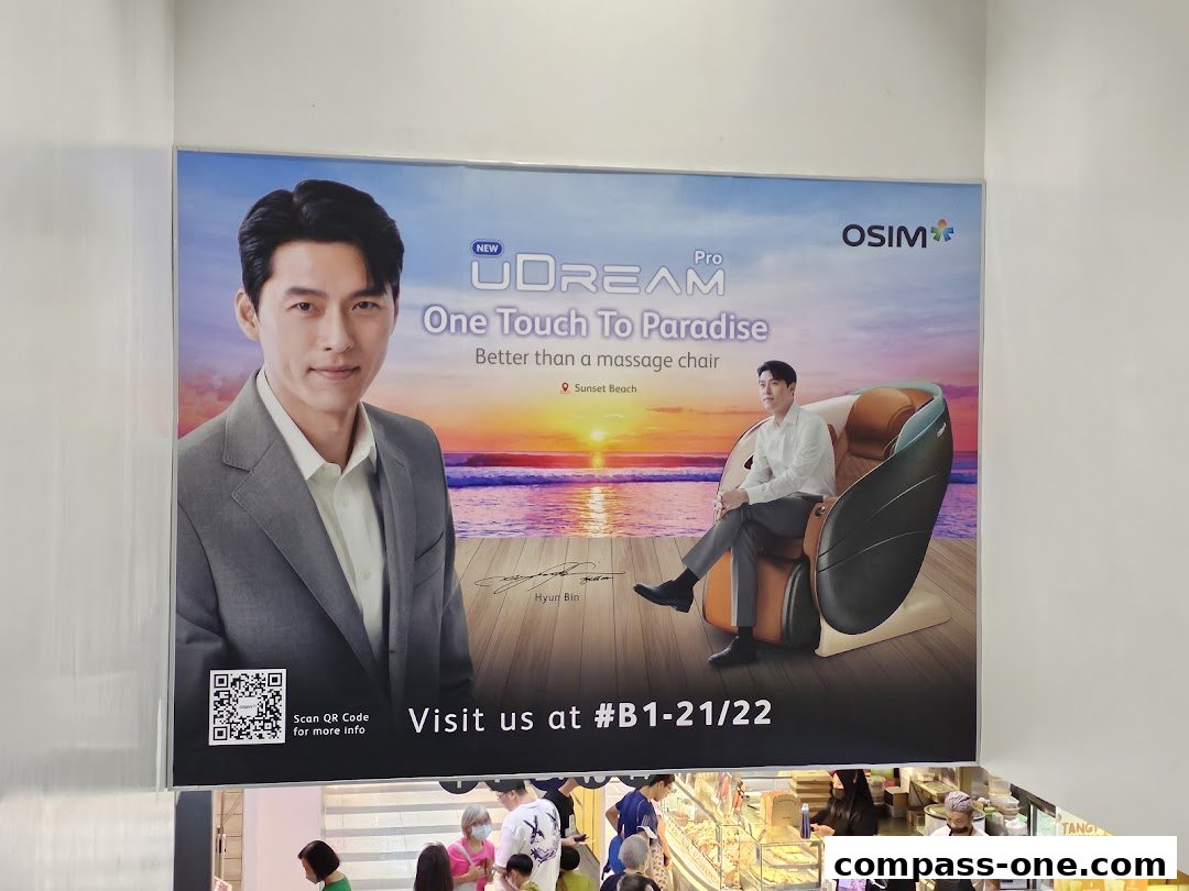 Advertisement for OSIM uDream Pro massage chair featuring Hyun Bin and a sunset beach scene.