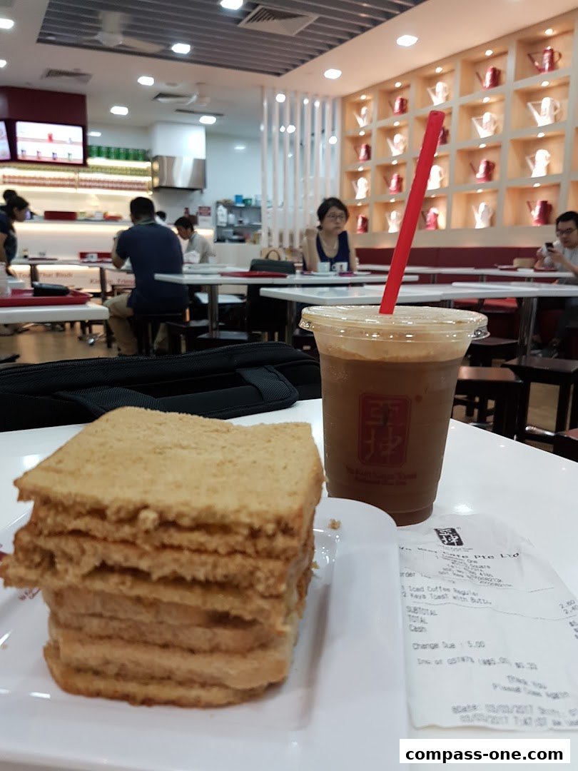 A stack of kaya toast and an iced coffee drink on a table at Ya Kun Kaya Toast.