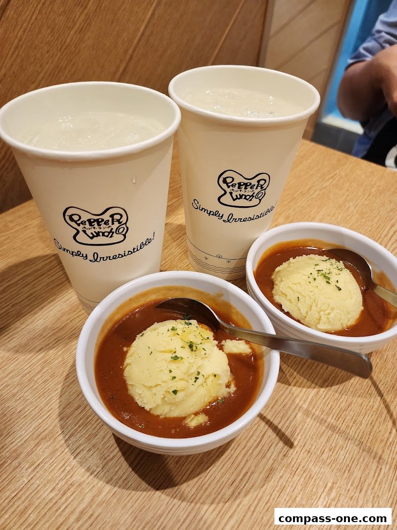 Two servings of mashed potatoes with gravy and two cups of drinks from Pepper Lunch.
