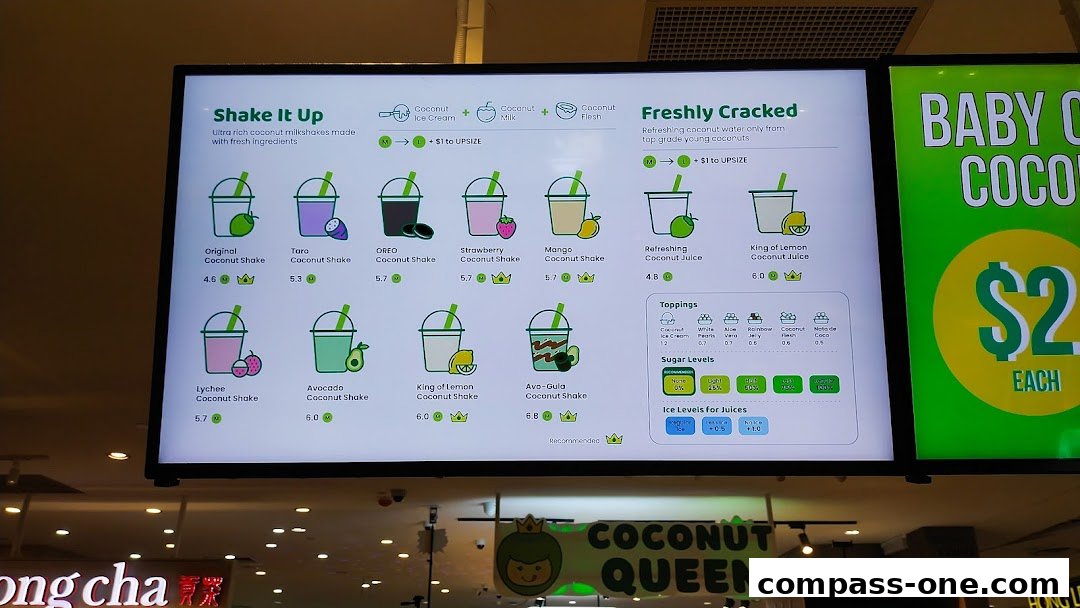 A digital menu board displaying various coconut shakes and juices with prices and ratings.