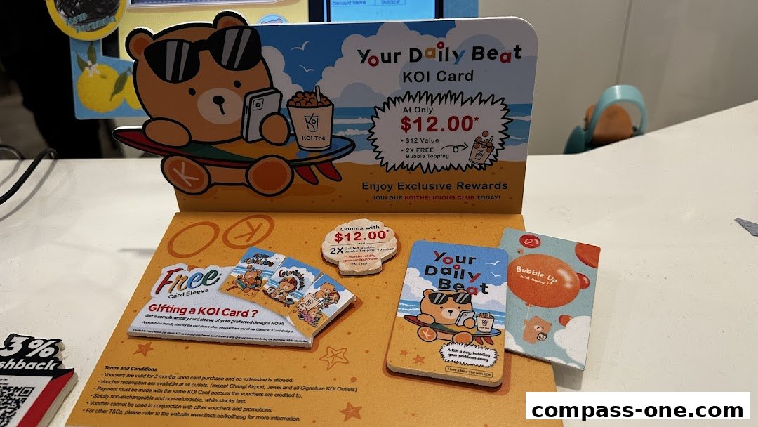 Promotional display for KOI Card with a cartoon bear, offering rewards and freebies.
