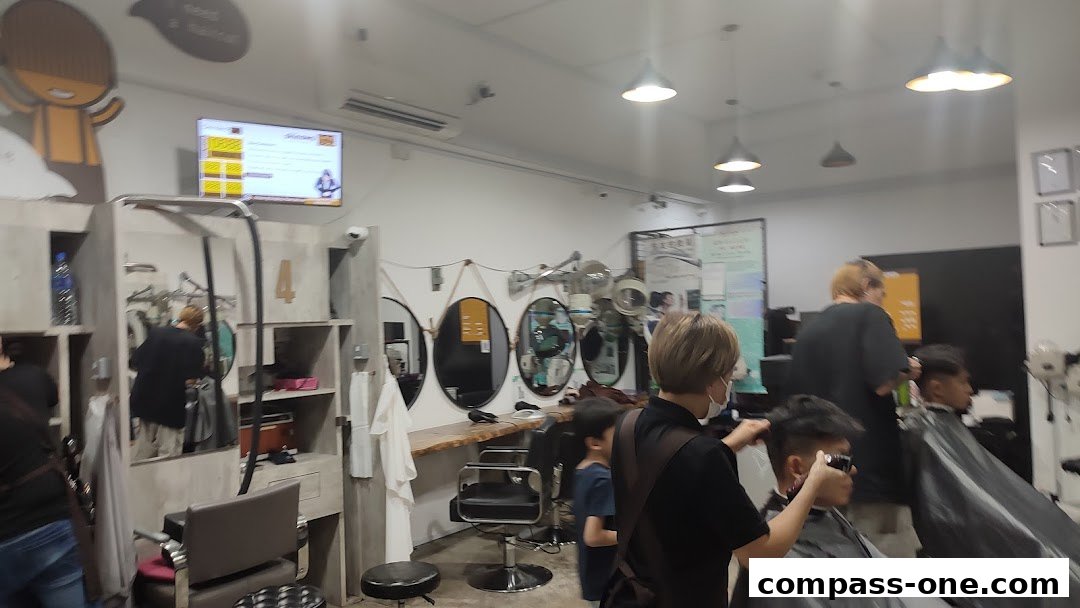 Interior view of a modern hair salon with stylists attending to clients.