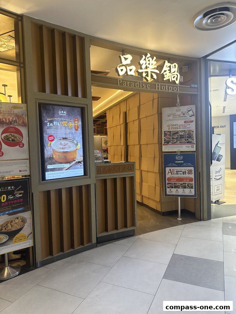 The entrance of Paradise Hotpot restaurant with its signage and promotional posters.