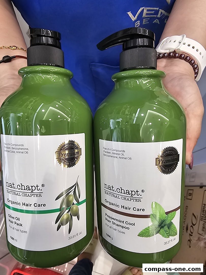 Two large green bottles of organic hair care products, one with olive oil and the other with peppermint.