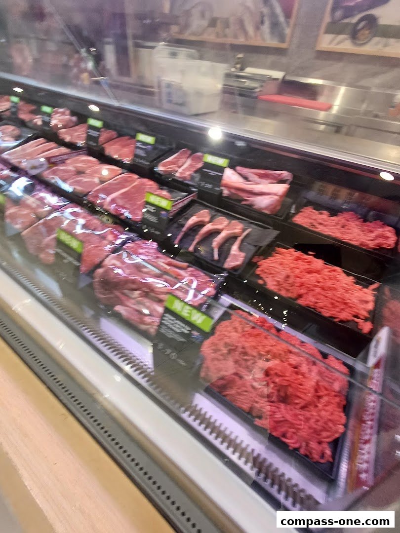 A display case filled with various cuts of fresh meat, including beef and lamb.