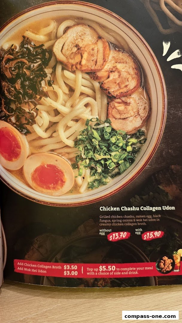 A close-up of a delicious bowl of Chicken Chashu Collagen Udon with eggs and toppings.