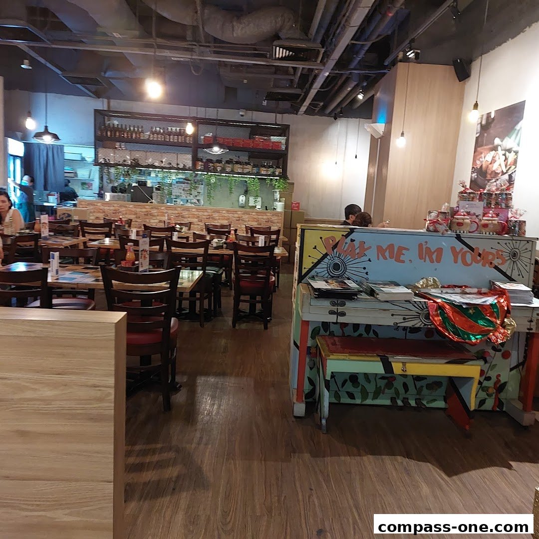 Interior of a restaurant with tables, chairs, and a decorated piano.