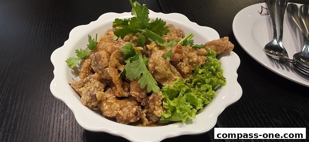 A close-up of crispy fried chicken pieces garnished with cilantro and lettuce.