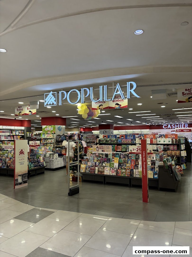 The entrance of a POPULAR bookstore, showcasing shelves filled with books and promotional displays.