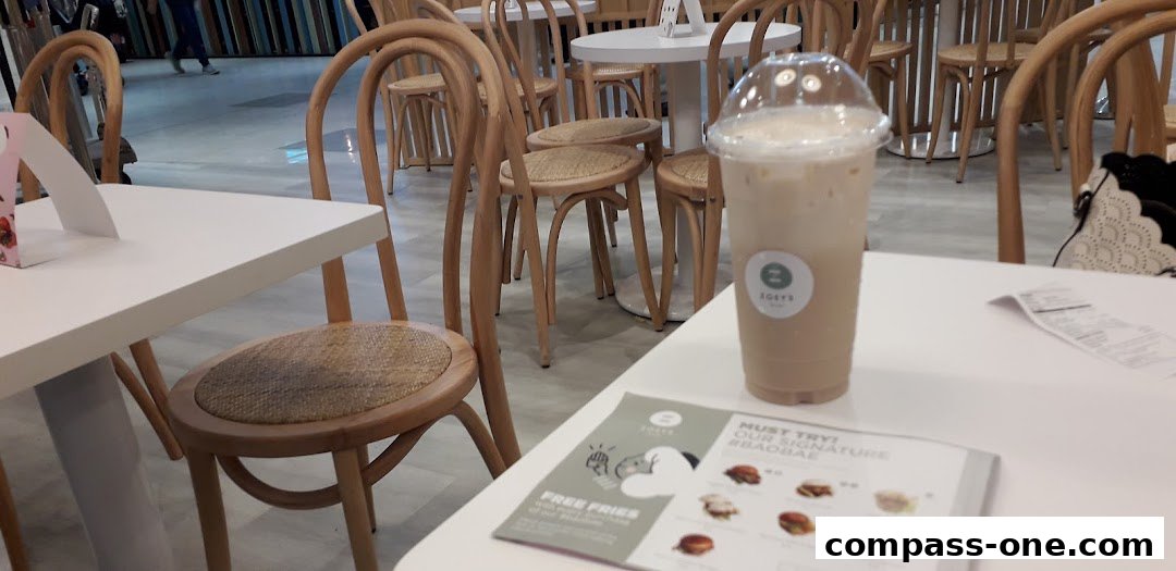 A table at Zoeys cafe with a drink and a menu featuring burgers and free fries.