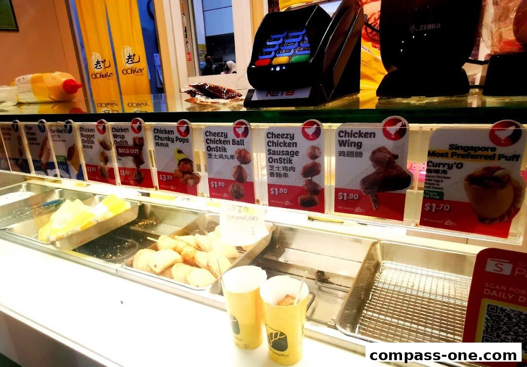 A display of various fried snacks and drinks at Old Chang Kee, with prices and product names visible.