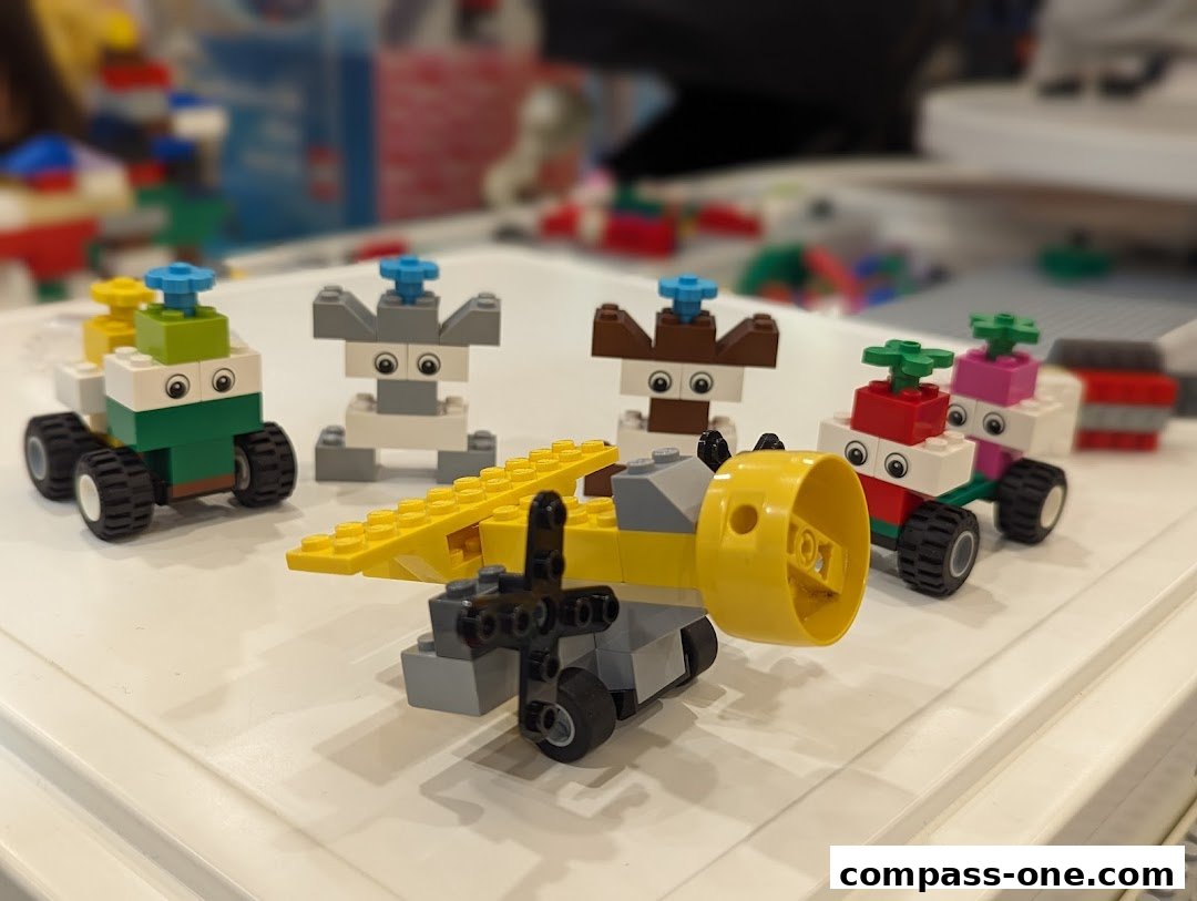 A collection of colorful LEGO creations, including a yellow airplane and several characterful vehicles with wheels and eyes.