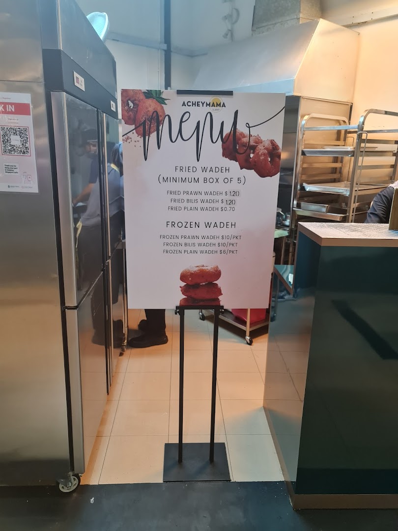 Acheymama's menu stand displaying prices for fried and frozen wadeh.