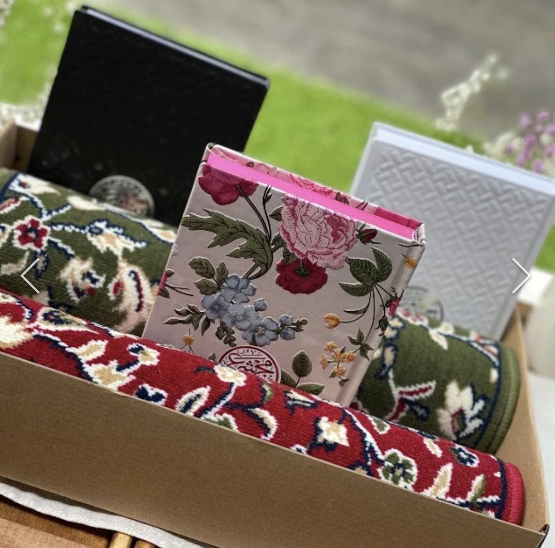 A gift box featuring prayer mats and Islamic books, perfect for thoughtful giving.