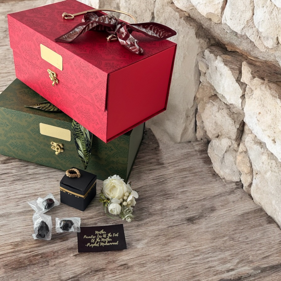 An elegant display of Islamic gifts featuring decorative boxes, dates, and a Kaaba-shaped item.