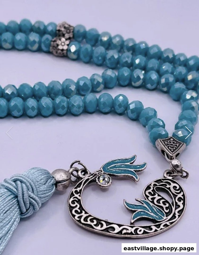 Close-up of beautiful blue faceted prayer beads with an ornate silver and enamel tassel.