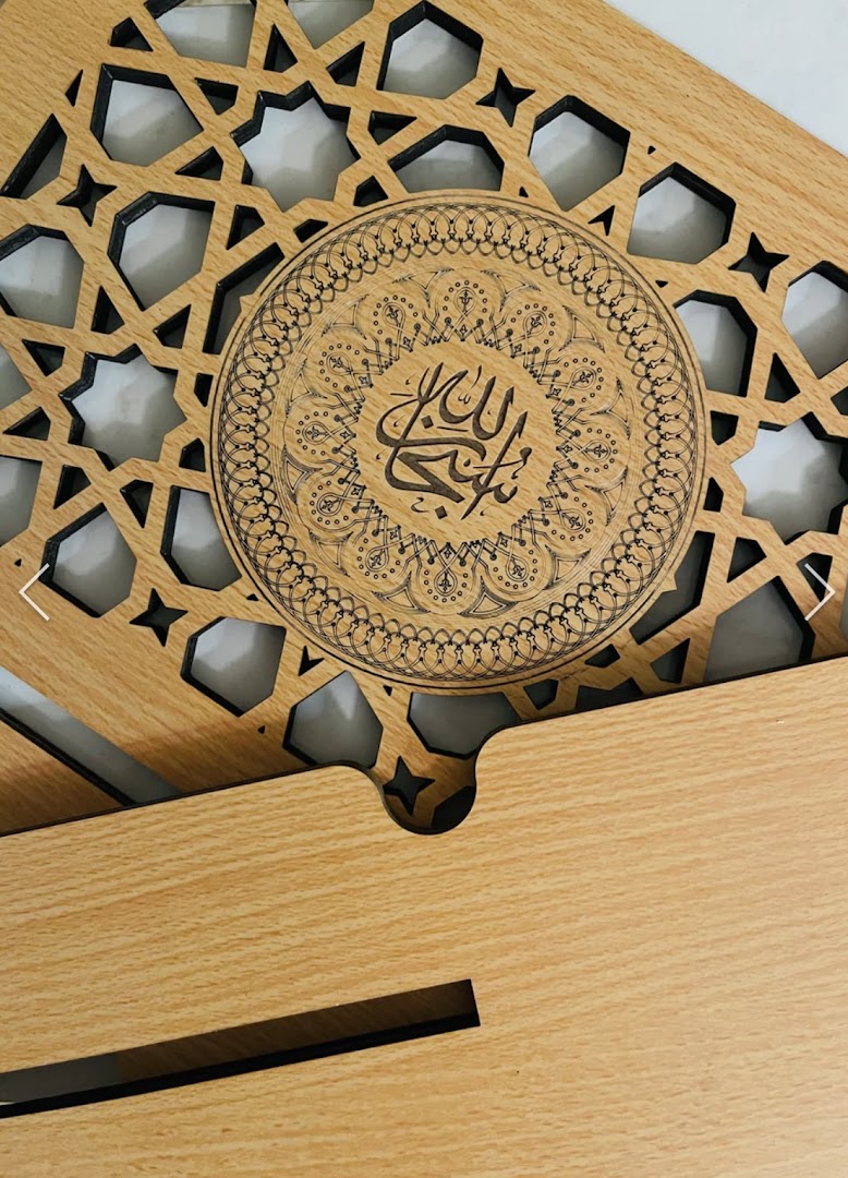 A wooden stand featuring intricate Islamic geometric patterns and elegant Arabic calligraphy.