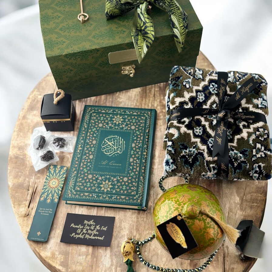 An elegant collection of Islamic gifts including a Quran, prayer mat, dates, and prayer beads.