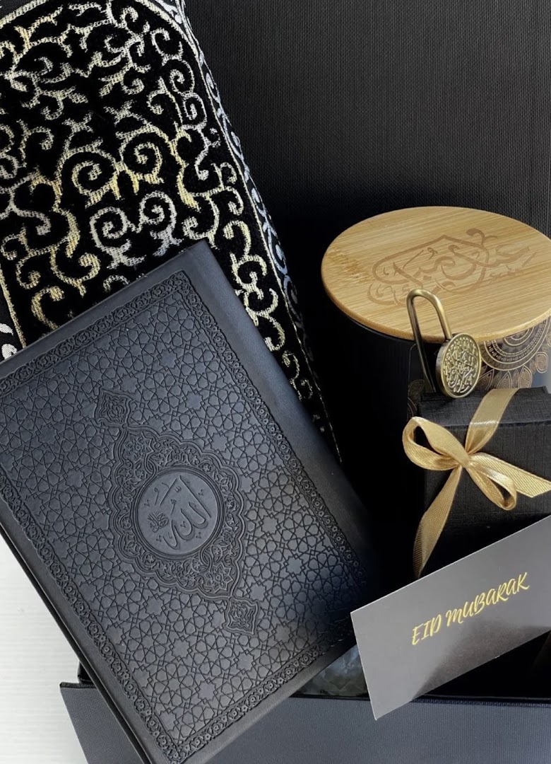 A beautifully arranged Islamic gift set featuring a Quran, prayer mat, and other elegant items.