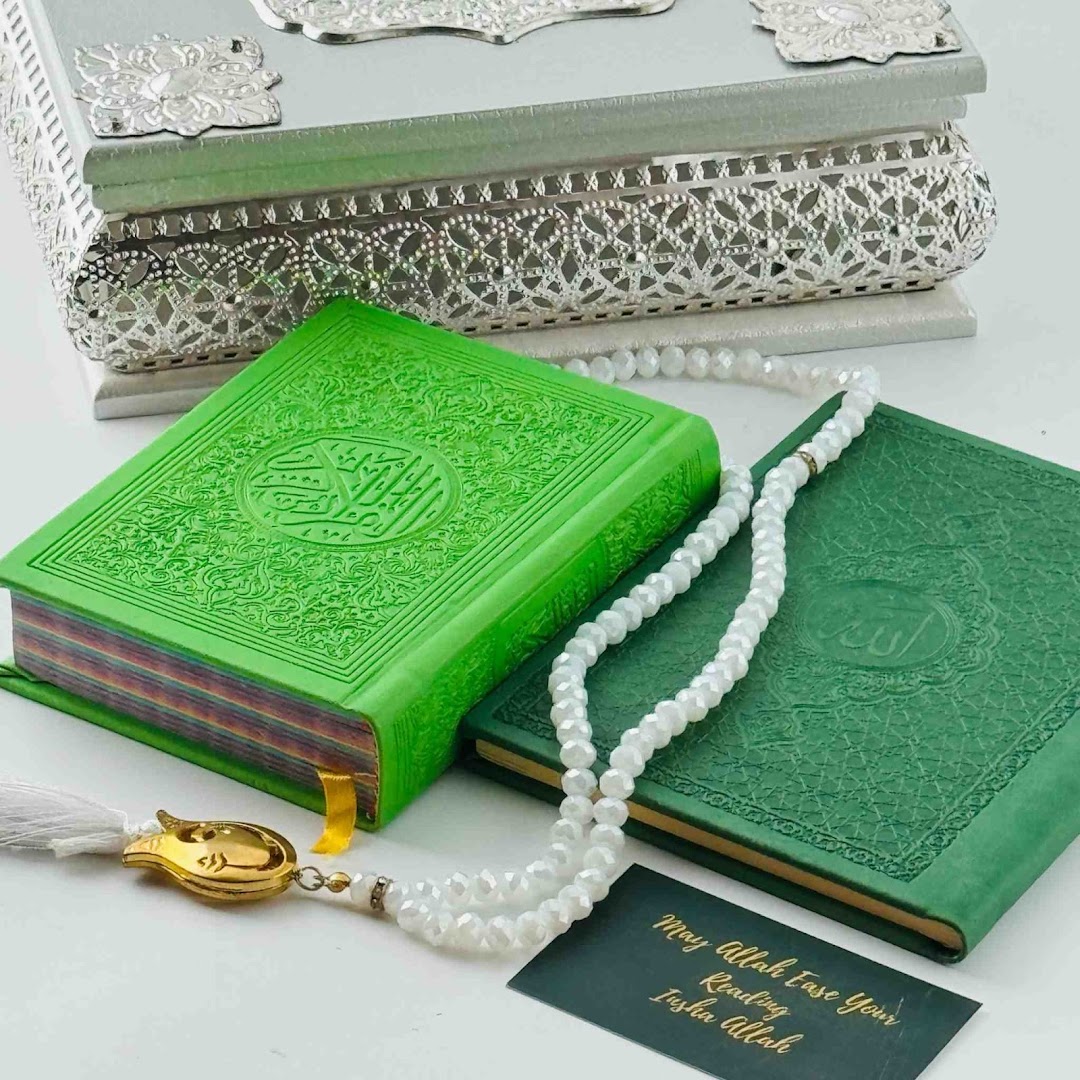 Two green Islamic holy books, prayer beads, and a decorative silver box, representing spiritual gifts.