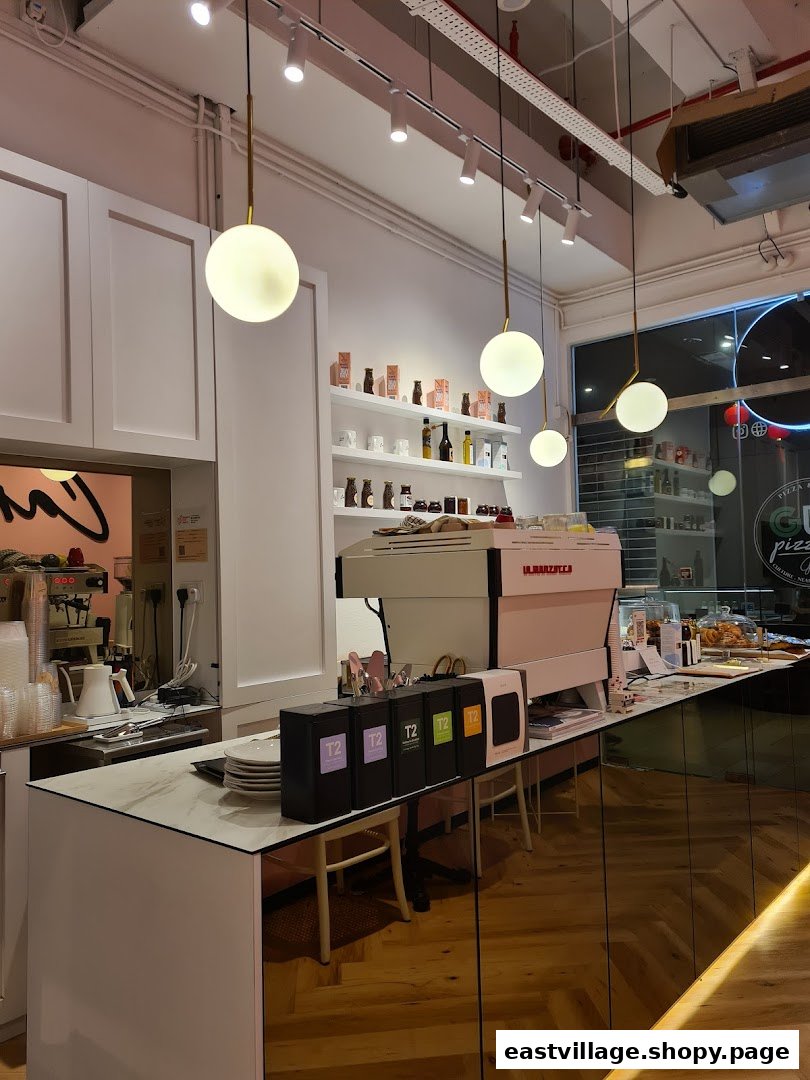 Interior view of Café Cartisan's counter with a coffee machine, T2 teas, and product shelves.