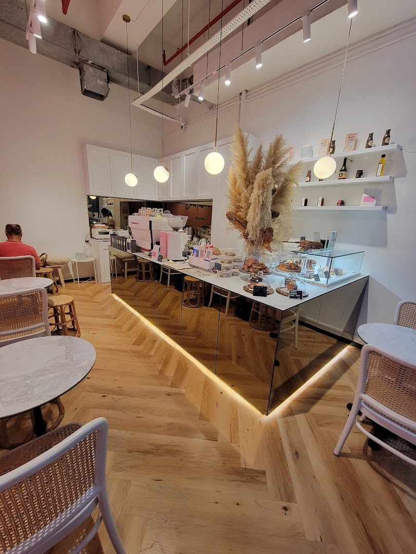 An inviting interior view of Café Cartisan, featuring a modern counter, display of pastries, and comfortable seating.