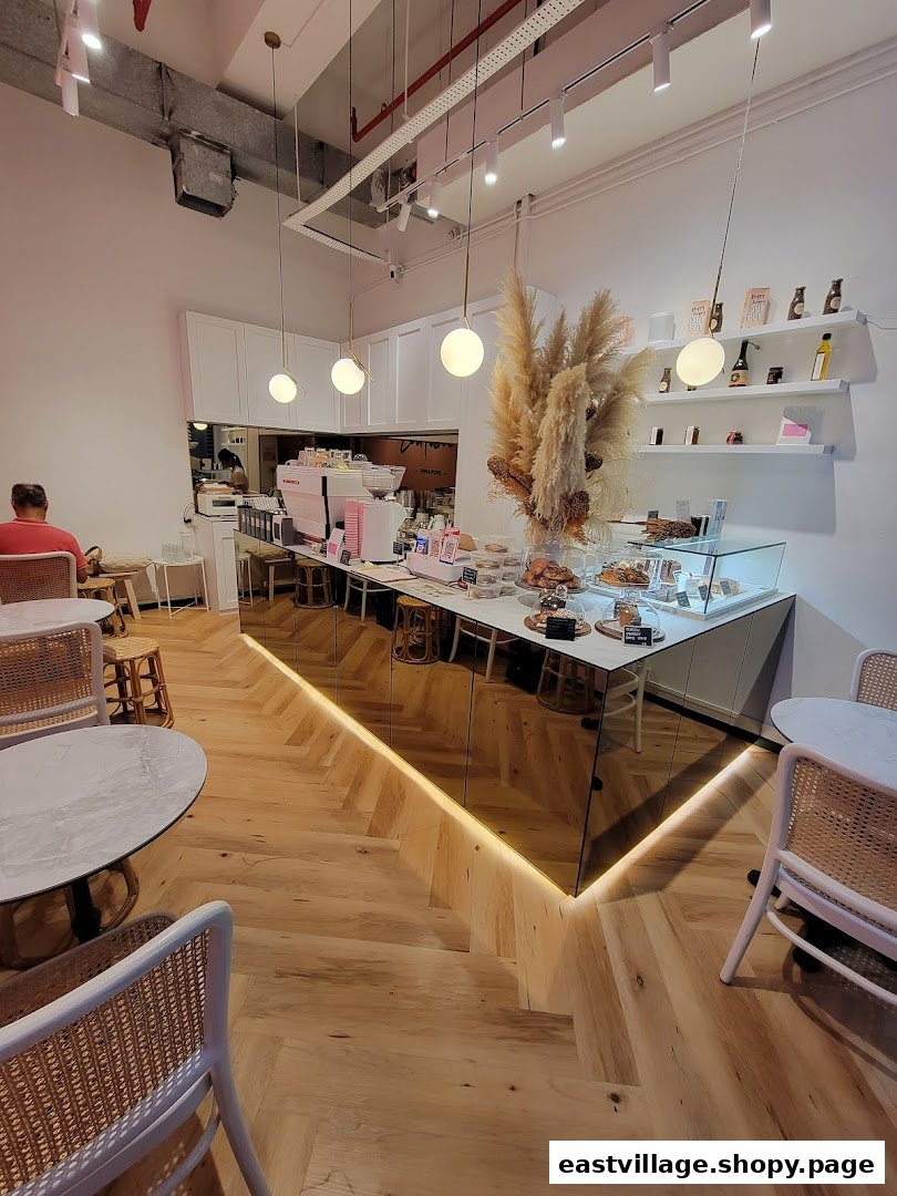 An inviting interior view of Café Cartisan, featuring a modern counter, display of pastries, and comfortable seating.