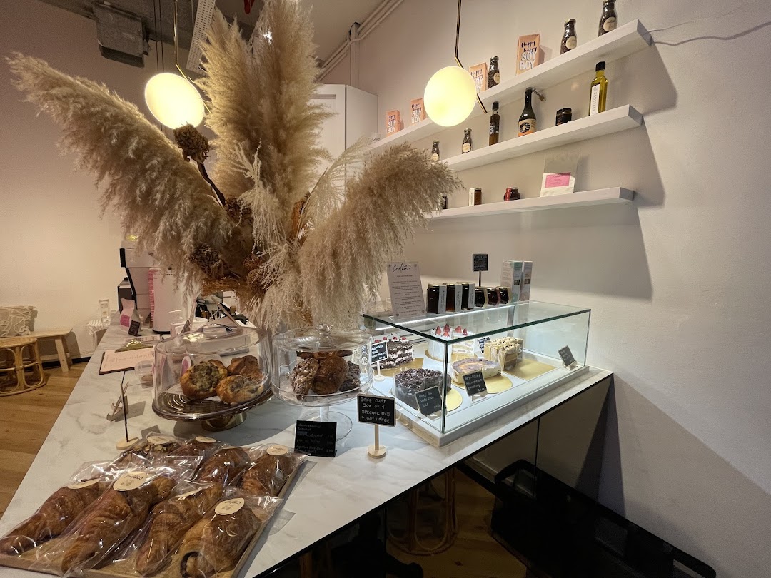 Interior view of Café Cartisan, showcasing a display of pastries, cakes, and retail products.