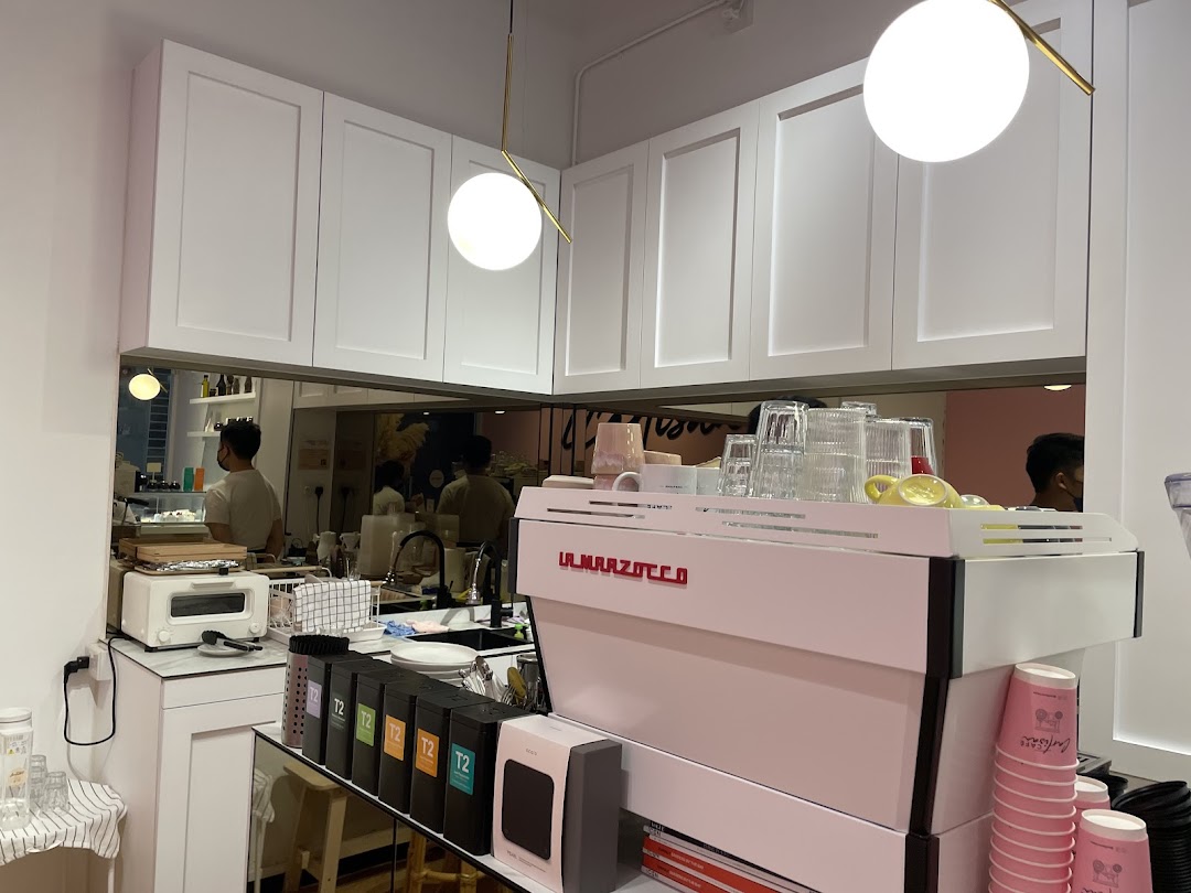 A clean, modern coffee bar with a white espresso machine and staff preparing drinks.