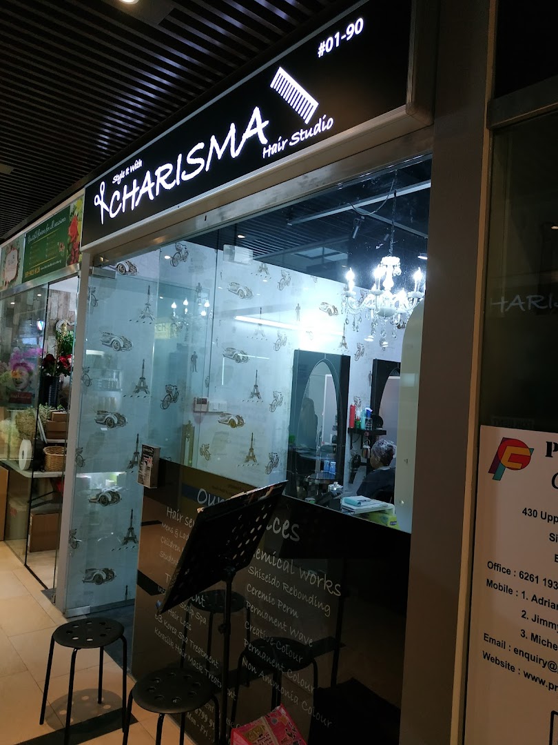 The brightly lit entrance of Charisma Hair Studio, featuring a stylish sign and glass facade.