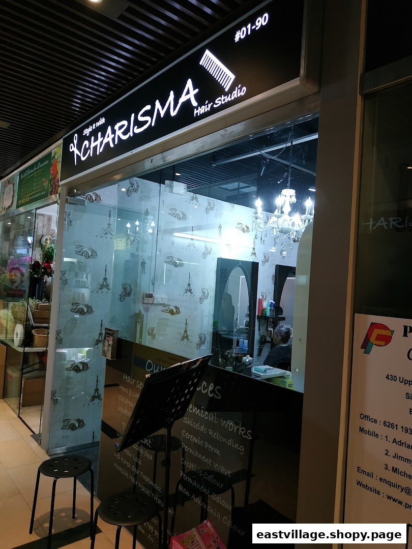 The brightly lit entrance of Charisma Hair Studio, featuring a stylish sign and glass facade.